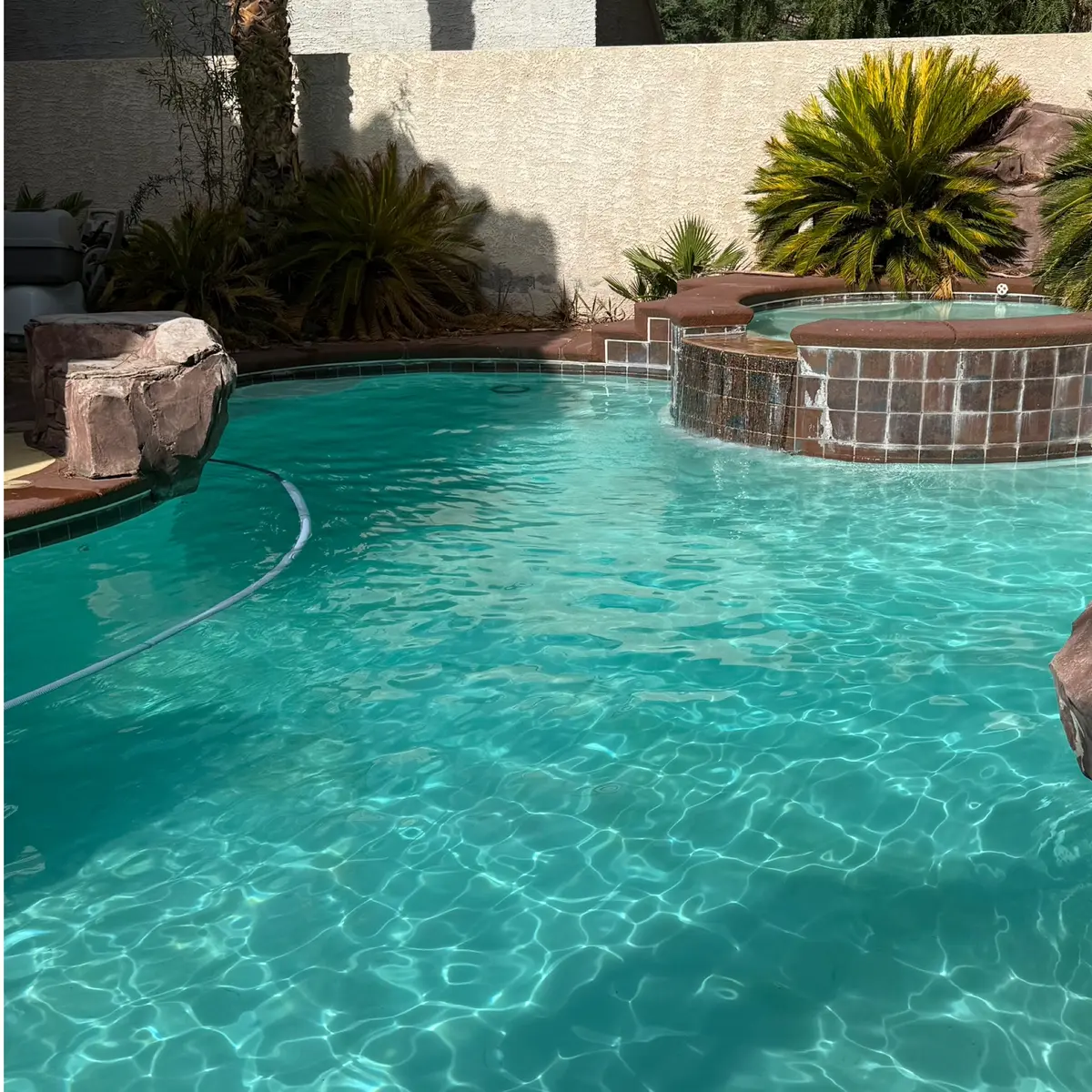 The same pool with clear turquoise water, the floor and spa tile visible